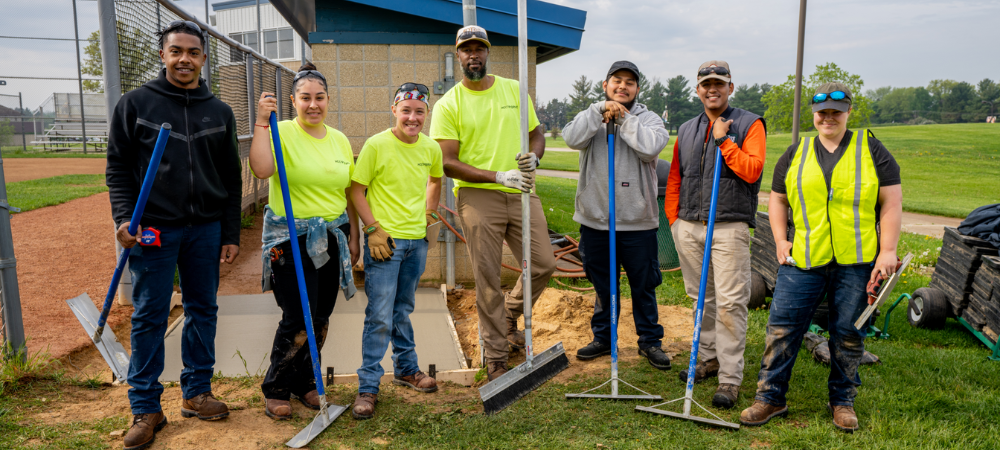 group of students learning how to pave cement during summer